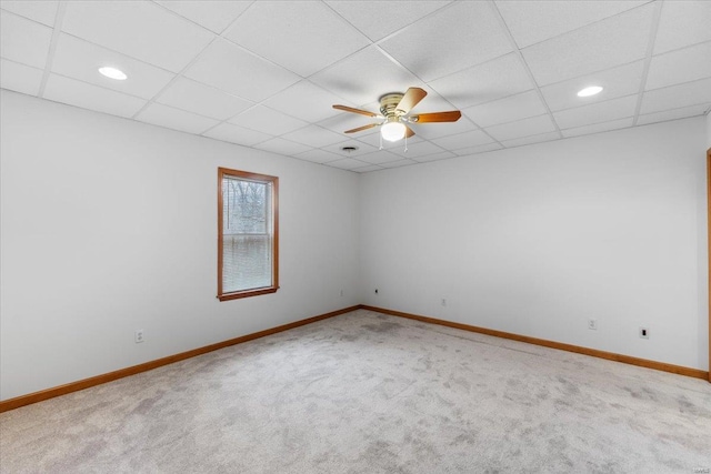 carpeted spare room featuring a paneled ceiling and ceiling fan