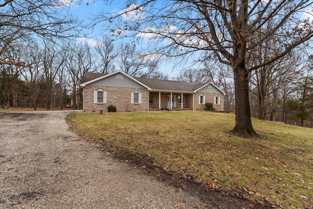 ranch-style house featuring covered porch and a front lawn