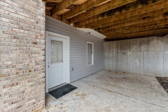 view of exterior entry with a patio area