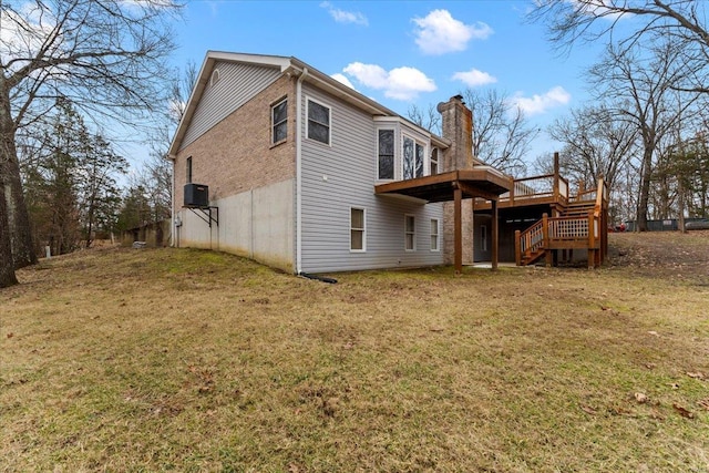 back of house featuring a deck, central AC unit, and a lawn