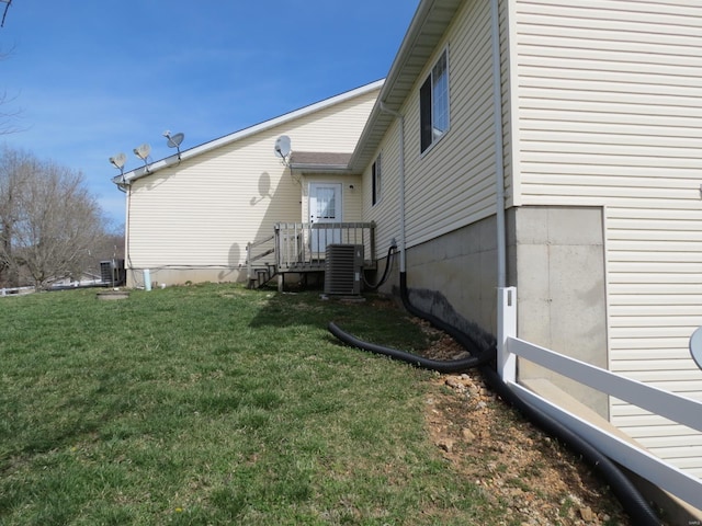 exterior space with central AC unit and a yard