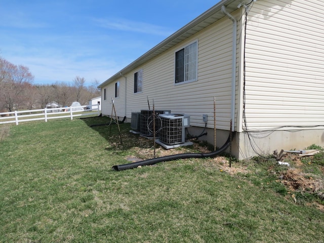 view of property exterior with a yard and central air condition unit