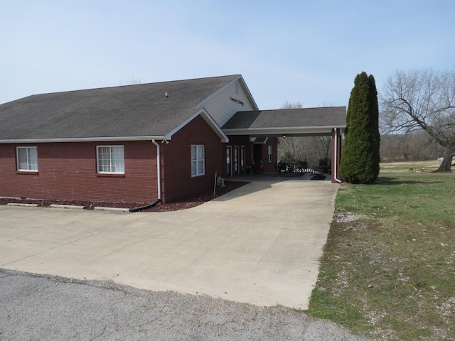 view of property exterior featuring a carport and a lawn