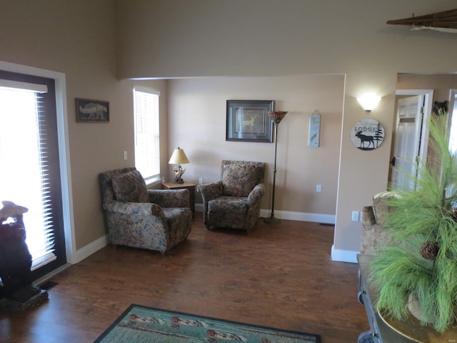 living room featuring a wealth of natural light and dark hardwood / wood-style flooring