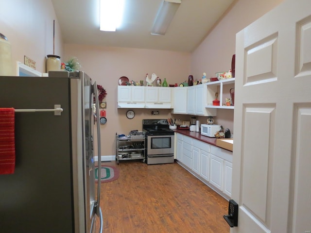 kitchen with appliances with stainless steel finishes, dark hardwood / wood-style floors, and white cabinets