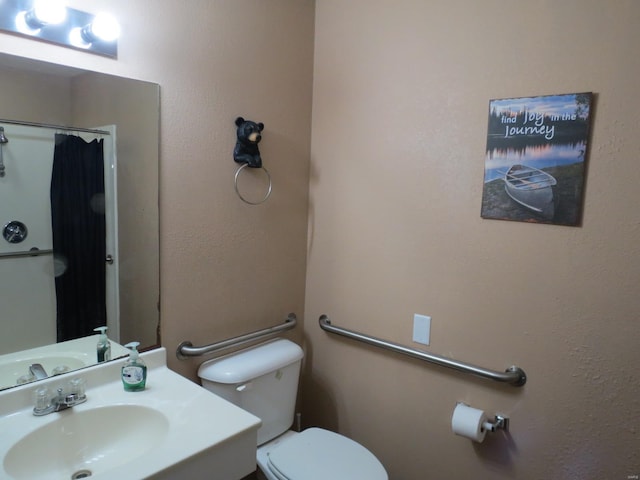 bathroom with sink, curtained shower, and toilet