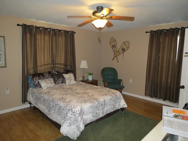 bedroom with dark hardwood / wood-style floors and ceiling fan