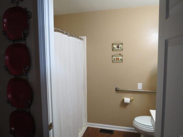 bathroom featuring hardwood / wood-style flooring and toilet