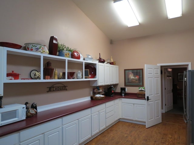 kitchen featuring white cabinetry, stainless steel refrigerator, and light hardwood / wood-style flooring