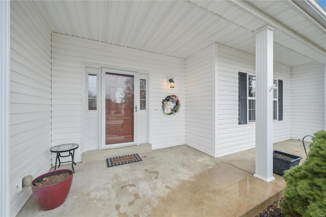 view of exterior entry featuring covered porch