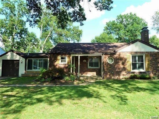 single story home with a garage and a front lawn