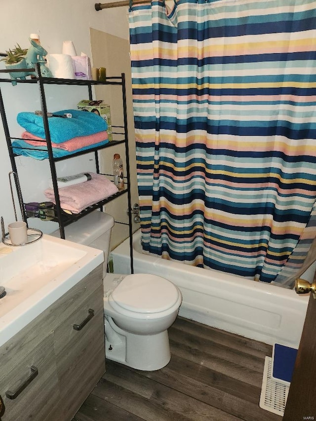 bathroom with hardwood / wood-style flooring, toilet, and shower / tub combo