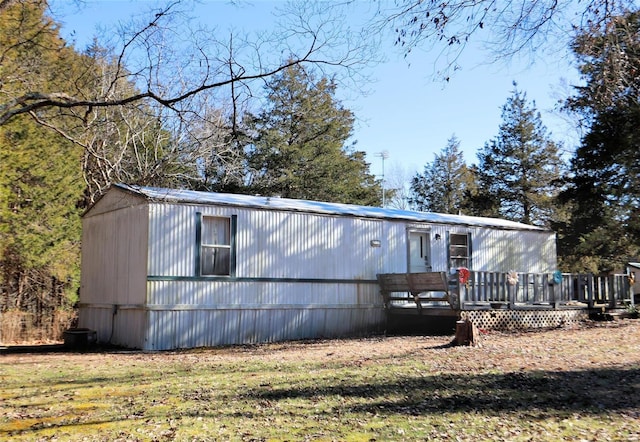 manufactured / mobile home with a wooden deck and a front lawn