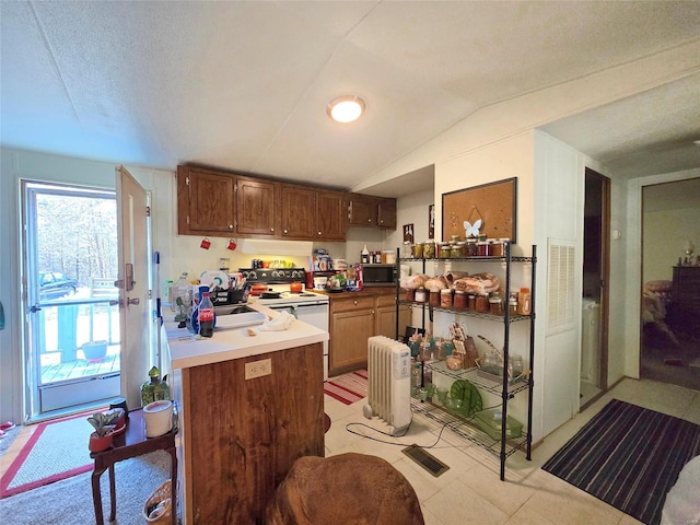 kitchen featuring electric stove, radiator heating unit, kitchen peninsula, and vaulted ceiling