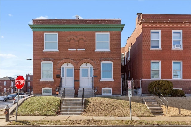 view of front of property with brick siding and a gate