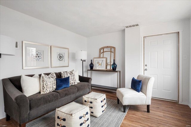 living area featuring visible vents and wood finished floors