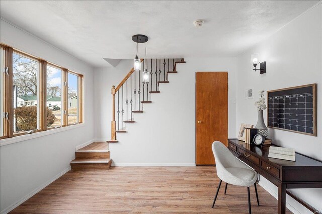 home office with light wood-style flooring, visible vents, and baseboards