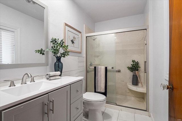 full bath featuring a stall shower, vanity, toilet, and tile patterned floors