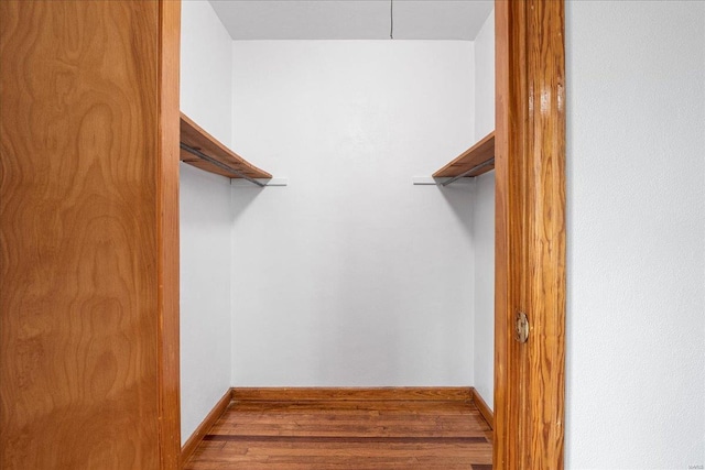 walk in closet with wood finished floors