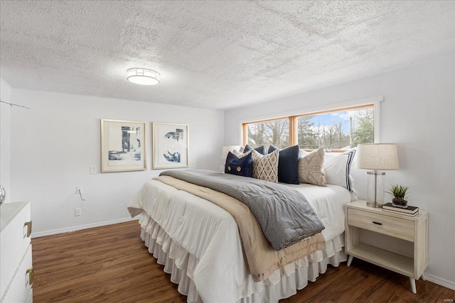 bedroom featuring a textured ceiling, wood finished floors, and baseboards