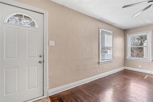 foyer with a textured ceiling, dark hardwood / wood-style floors, and ceiling fan