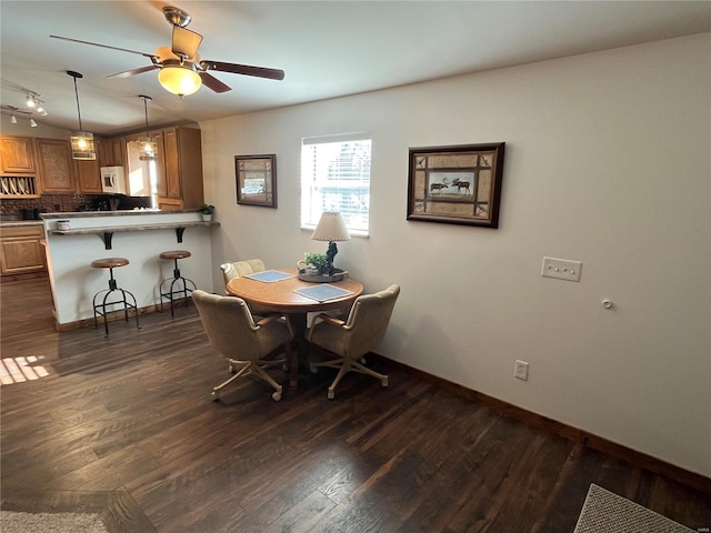 dining space with ceiling fan and dark hardwood / wood-style floors