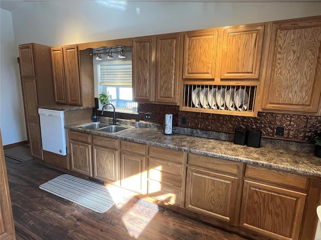 kitchen featuring tasteful backsplash, sink, dark wood-type flooring, and dishwasher