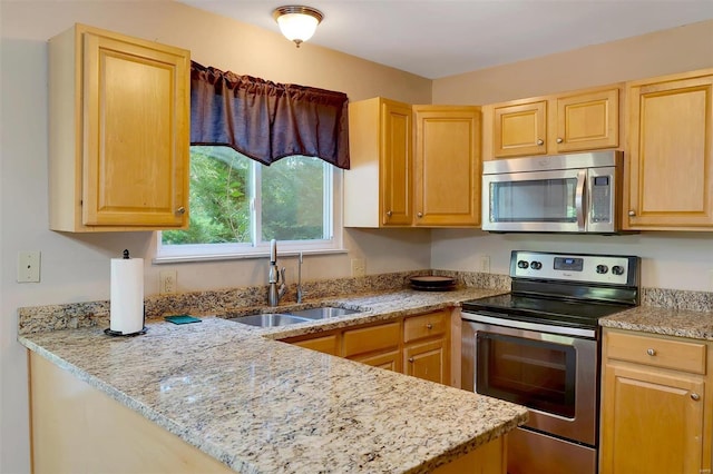 kitchen with stainless steel appliances, light stone countertops, sink, and light brown cabinets