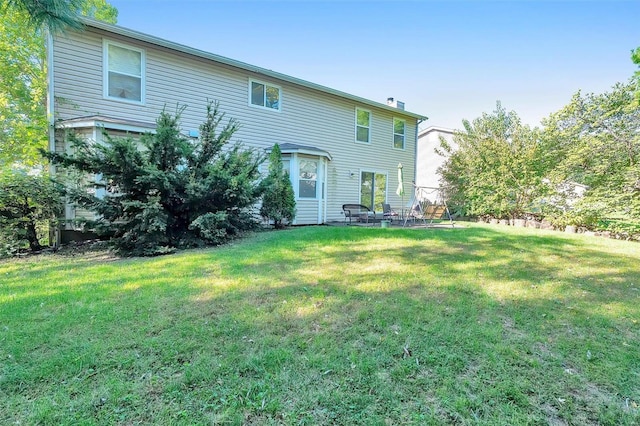 back of house featuring a lawn