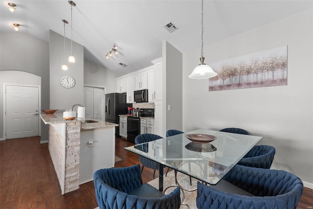 dining area featuring vaulted ceiling, dark hardwood / wood-style floors, and sink