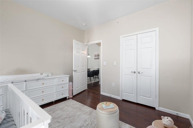 bedroom with dark hardwood / wood-style floors and a closet