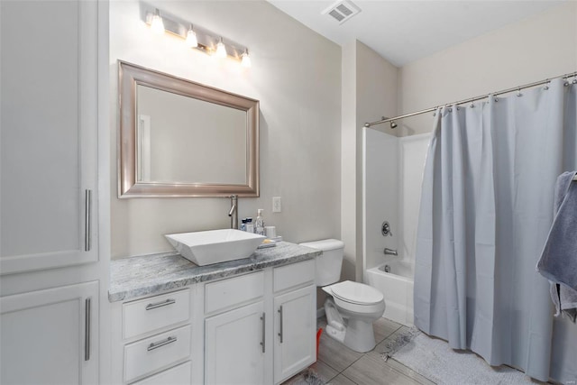 full bathroom featuring vanity, shower / bath combination with curtain, and toilet