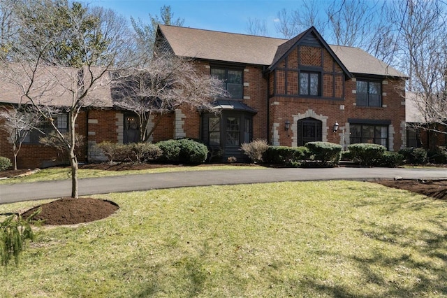 view of front of house featuring brick siding and a front lawn