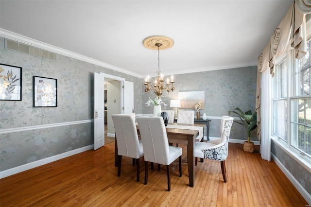 dining room with wallpapered walls, a notable chandelier, baseboards, and light wood finished floors