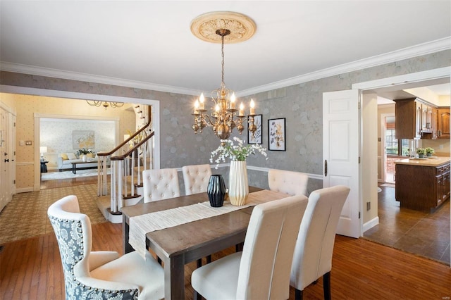 dining room featuring a notable chandelier, wallpapered walls, stairs, and wood finished floors