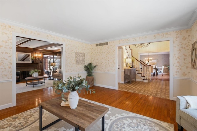 living room featuring wallpapered walls, a notable chandelier, and wainscoting