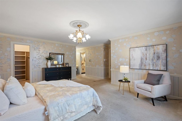 bedroom with a notable chandelier, a wainscoted wall, and wallpapered walls