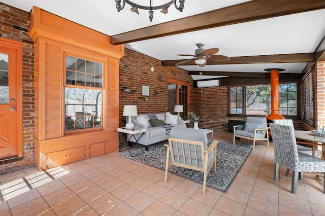 living room featuring beamed ceiling, light tile patterned floors, a ceiling fan, and brick wall