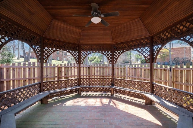 view of patio featuring a gazebo, ceiling fan, and fence