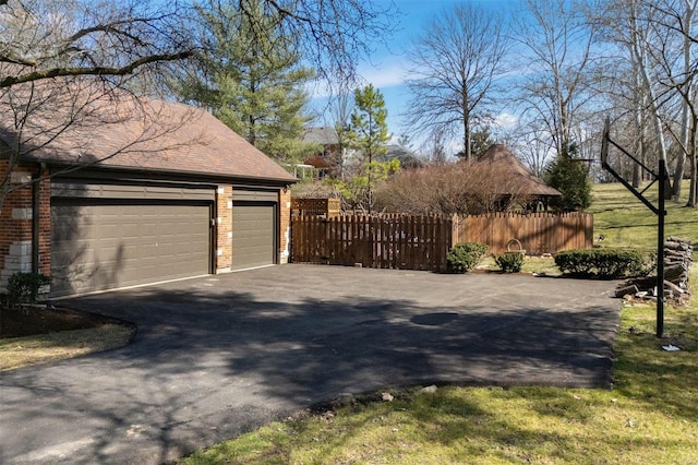 garage featuring fence and driveway