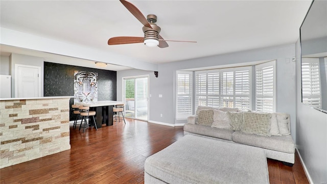 living room featuring ceiling fan and dark hardwood / wood-style floors