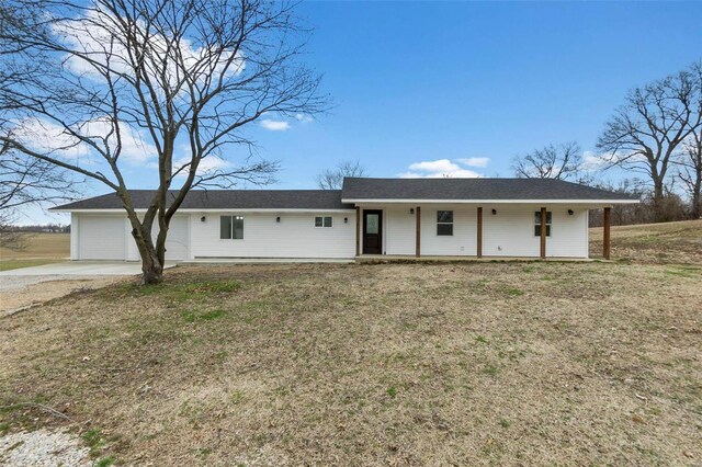 ranch-style home with a garage, a front yard, and concrete driveway