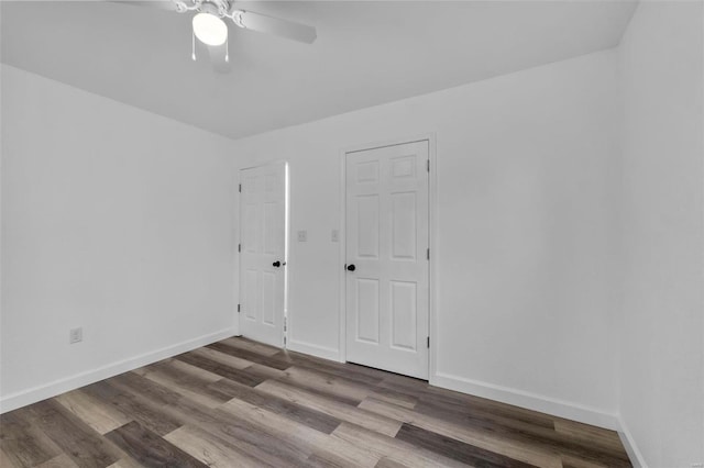 unfurnished room with ceiling fan, baseboards, and wood finished floors