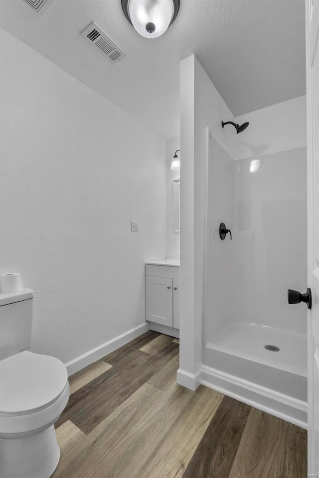 full bathroom featuring visible vents, walk in shower, wood finished floors, and vanity