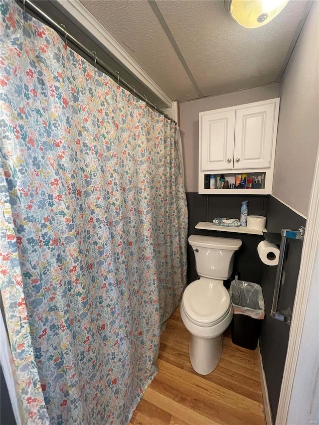 bathroom with hardwood / wood-style floors, a textured ceiling, and toilet