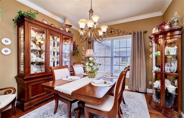 dining room with wood-type flooring, ornamental molding, and a chandelier