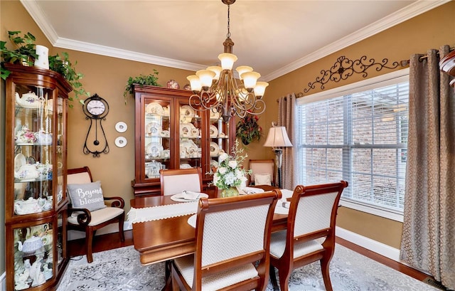 dining space featuring hardwood / wood-style flooring, ornamental molding, plenty of natural light, and a chandelier