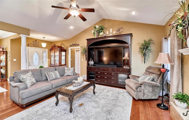 living room featuring decorative columns, wood-type flooring, lofted ceiling, and ceiling fan