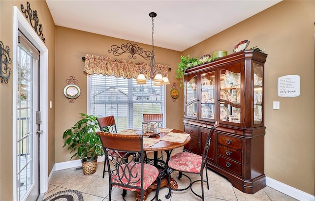 tiled dining area featuring a wealth of natural light and an inviting chandelier