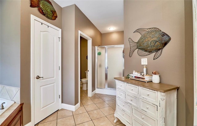 bathroom with toilet, plus walk in shower, and tile patterned flooring